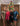 Four women posing in front of a decorated Christmas tree indoors.