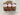 Three packages of banana bread with 'Misericordia' labels on a speckled countertop.