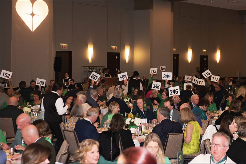 People in a conference room with numbered signs raised, possibly voting or participating in a survey.