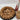 Assorted cookies on a platter with a Santa-themed bottle in the background.