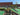 Miniature golf course with players and a building in the background