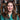 Woman with a surprised expression in front of framed pictures
