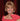 Woman with short blonde hair wearing a red dress on a red background