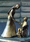 Bronze sculpture of a woman and child on a pedestal