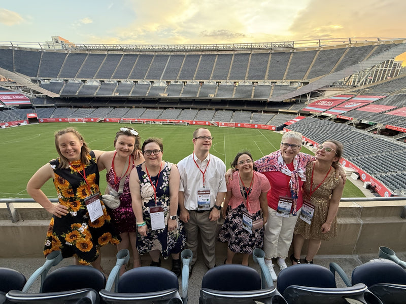 Group of people posing for a photo in a stadium