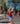 Woman running in a race with a red tank top and blue shorts, celebrating her achievement.