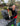 Man using a compost bin outdoors with a garden tool