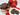 Chocolate cookies in a gold tin with a red heart-themed box on a white wooden surface.